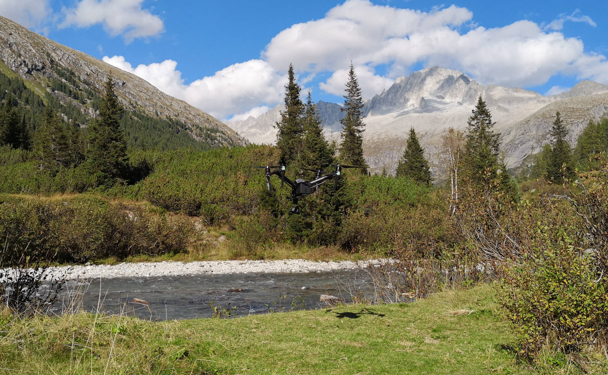 drone avente sfondo un paesaggio montano con fiume